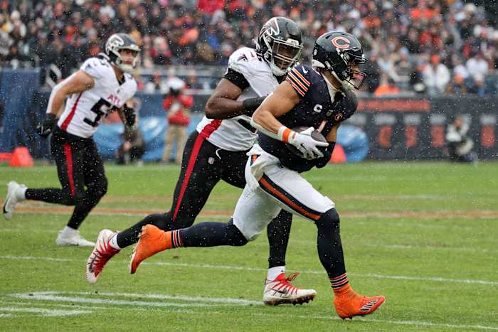 Dec 31, 2023; Chicago, Illinois, USA; Chicago Bears quarterback Justin Fields (1) rushes the ball past Atlanta Falcons defensive end Zach Harrison (96) during the first half at Soldier Field.